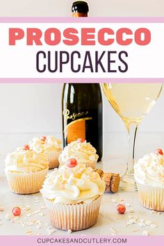 three cupcakes with white frosting next to a bottle of champagne