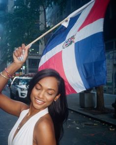 a woman holding a flag in the street