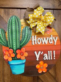 a wooden sign that says howdy y'all with a cactus and flowers on it