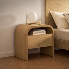 a bed room with a neatly made bed and a night stand next to the bed