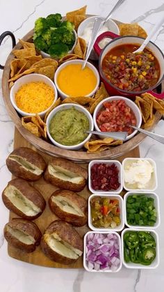 a platter filled with different types of food and condiments next to tortillas