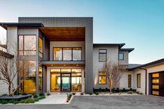 a large modern house with lots of windows on the front and side of it's building