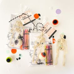 halloween crafting supplies including crayons, yarns and skeleton decorations on a white surface