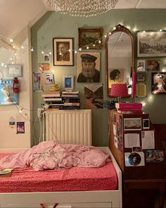 a bedroom with a bed, dresser and pictures on the wall