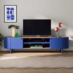 a blue entertainment center with a flat screen tv on it's stand in a living room