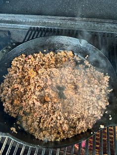 the food is cooking on the grill in the pot and it's being cooked