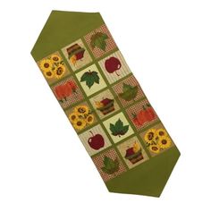 a green tie with an apple, sunflowers and leaves on it's side