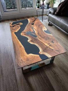 a coffee table made out of wood with black and blue paint on it in a living room