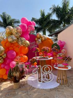 an outdoor party with balloons and decorations on the ground, including a table for two