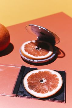 two grapefruits cut in half sitting on a table next to a mirror