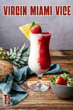 a smoothie in a glass with strawberries on the rim and pineapples next to it