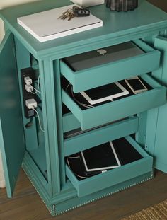 a blue cabinet with two drawers and an electronic device in it's bottom drawer