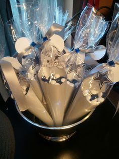 a silver vase filled with white flowers and plastic wrapper wrapped in cellophane