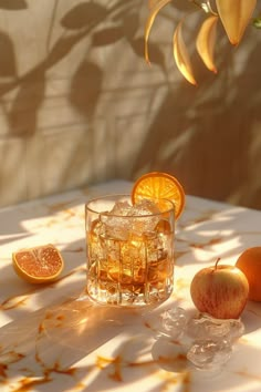 an apple and orange sitting on top of a table next to some ice cubes