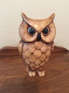 an owl figurine sitting on top of a wooden table