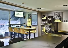 an office with yellow chairs and sports jerseys hanging on the wall in front of windows