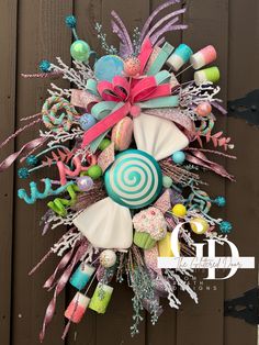 a wreath with candy, lollipops, and other decorations on the front door