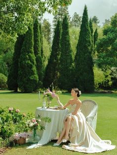 a woman sitting at a table in the grass