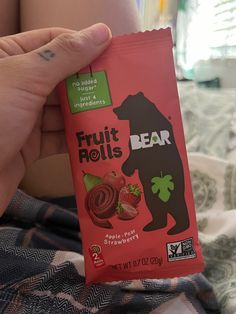 a hand holding a bar of fruit rolls with bear on the front and strawberry on the back