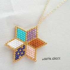 a cross stitched star on a gold chain