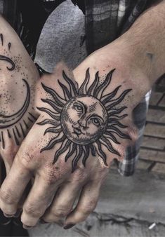 two hands with sun and moon tattoos on them