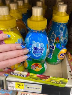 a woman's hand is holding up a bottle of baby formulas in a store