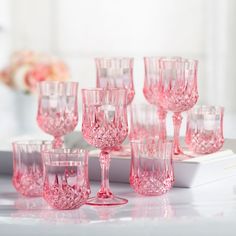 many pink glasses are lined up on a table