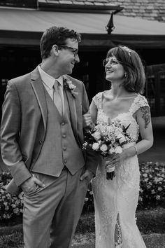 a man and woman standing next to each other in front of a flower garden at their wedding