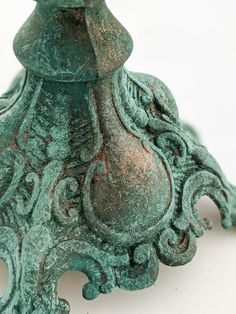 an ornate green vase sitting on top of a white table