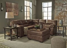 a living room filled with furniture and a large brown sectional couch sitting on top of a rug