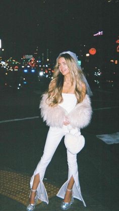 a woman is dressed in white and posing for the camera with her fur stole around her neck