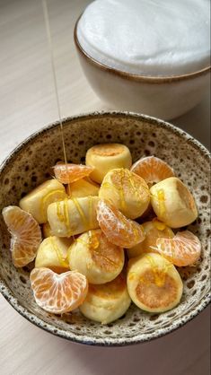 a bowl filled with sliced oranges on top of a table