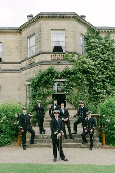 a group of men in suits and ties sitting on the steps of a large building