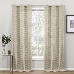 the curtains are hanging in front of a window with white walls and wood flooring