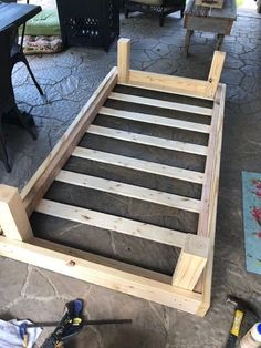 a wooden bed frame sitting on top of a patio