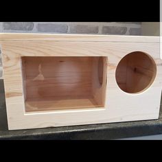 a wooden box with two holes in the front and one hole in the back that is open