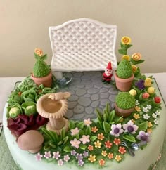 there is a cake decorated with flowers and cacti in the shape of a bench