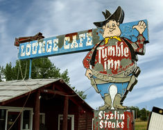 a large sign for a store with a man holding a cowboy hat on it's back