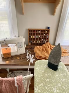 a sewing machine sitting on top of a wooden table next to a green and white chair