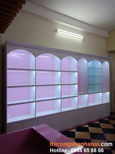 an empty room with pink shelves and black and white checkerboard flooring on the walls