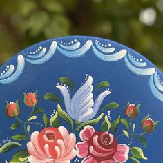 a painted blue plate with flowers on it