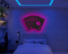 a bed room with a neatly made bed and neon signs on the wall above it