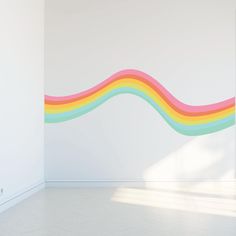 an empty room with a rainbow painted on the wall