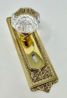 a golden door handle with a crystal knob on it's side and a keyhole in the middle