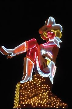 a neon sign with a cowboy on top of it