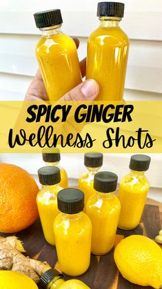 a person holding up some bottles with yellow liquid in them and the words spicy ginger wellness shots