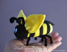 a small yellow and black toy bee sitting on someone's hand