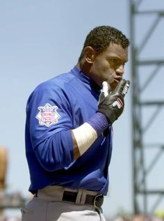 a baseball player is holding his glove up to his ear while standing in the outfield