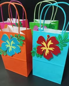 three colorful bags with flowers on them sitting next to each other, one blue and one orange