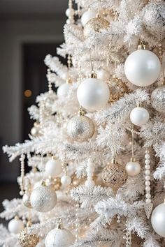 a white christmas tree with gold and silver ornaments